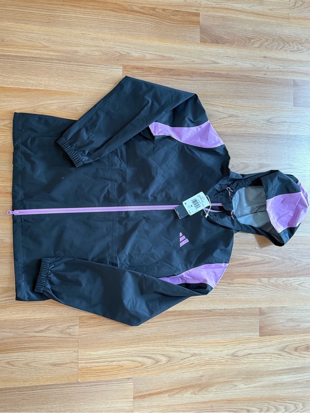 Adidas Women's RAIN.RDY Jacket in black with purple accents.